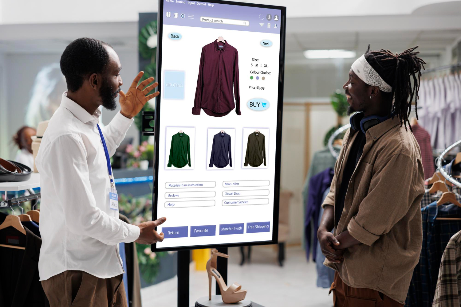 Two shoppers examine a large touchscreen display showing clothing options, with various shirt styles and purchase options available.
