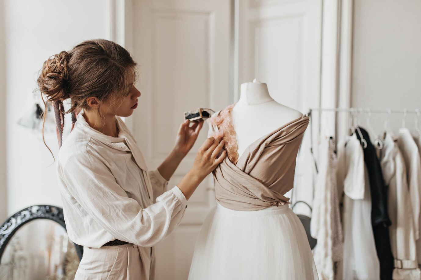 A designer adjusts a dress on a mannequin in a stylish studio