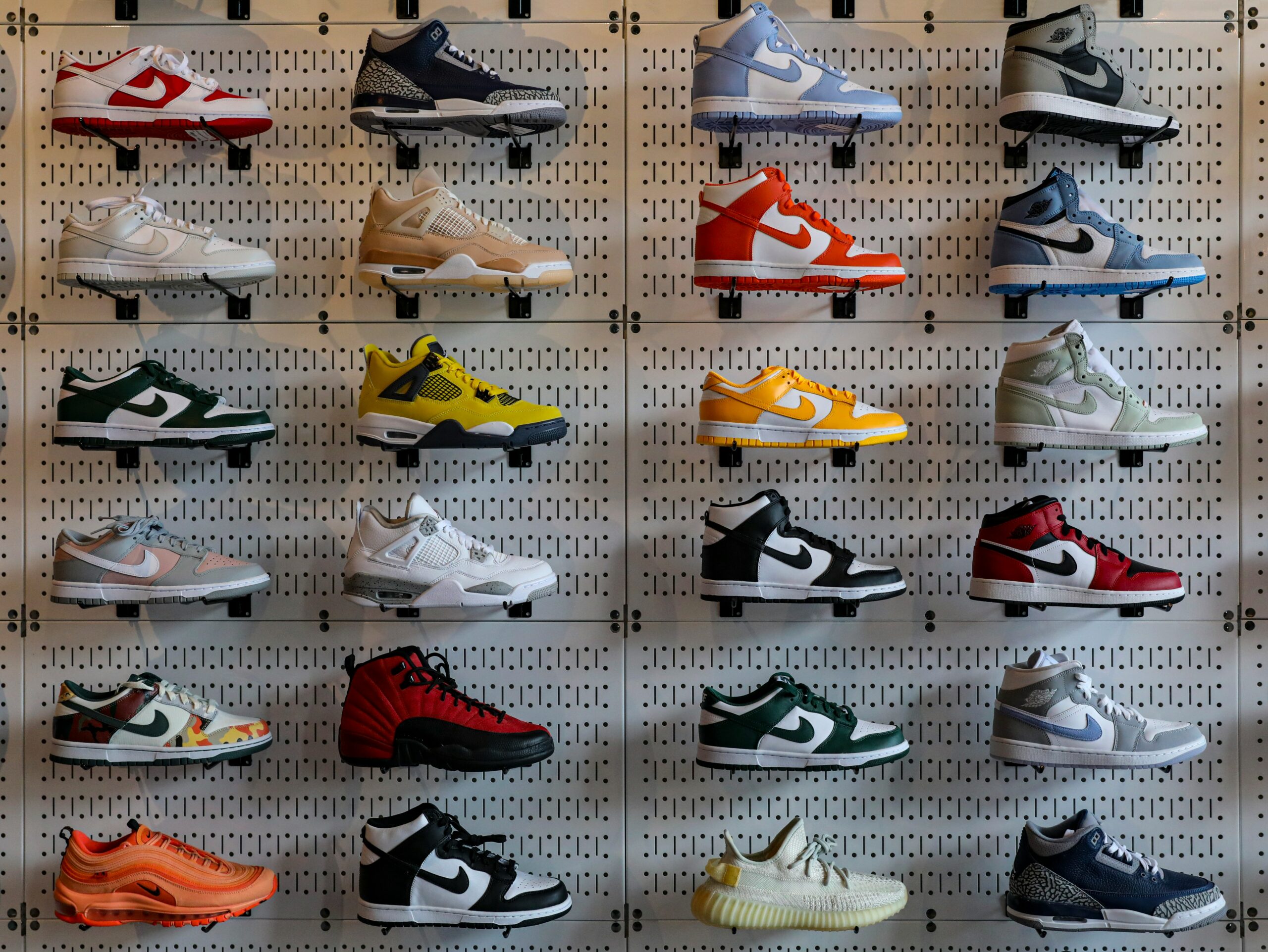 The various stylish sneakers on a pegboard, showcasing multiple Nike models in diverse colors and designs.