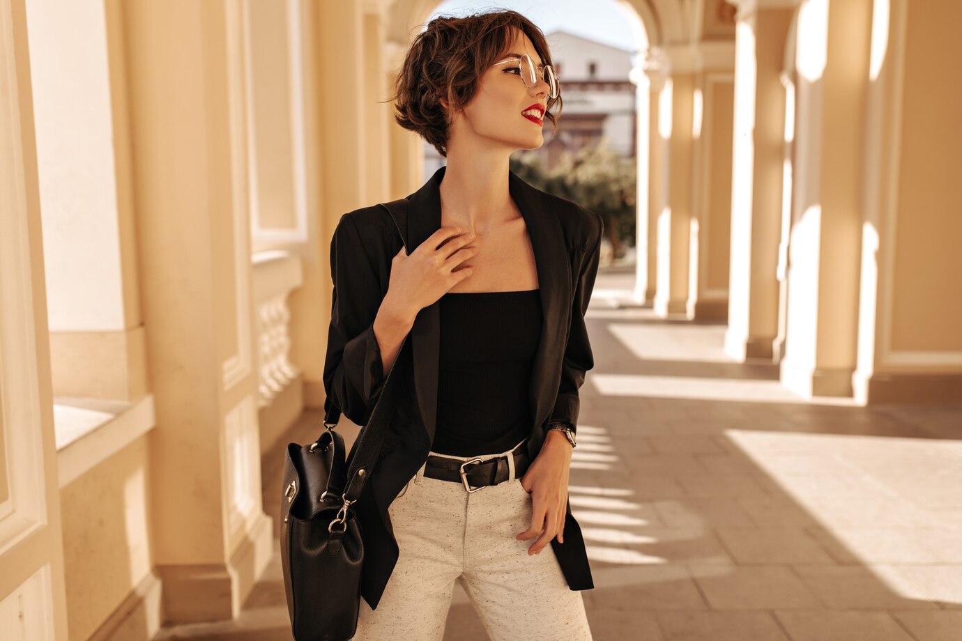 A stylish person wearing a black blazer and white pants